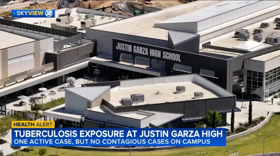 Aerial view of Justin Garza High School, with a news chyron at the bottom reporting a tuberculosis exposure at the school. ABC 30