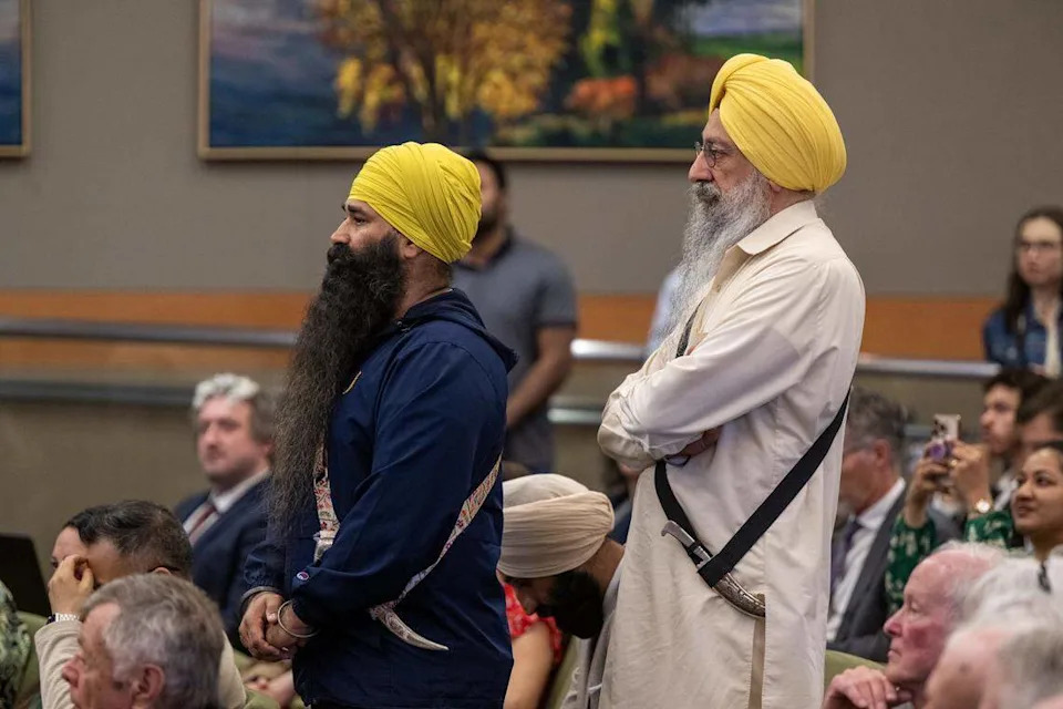 Mandeep Singh, left, and Dr. Gurtej Singh wear kirpans as they join dozens of Sikh community members on Tuesday at the first Sacramento City Council meeting where the ceremonial blades were allowed after the council created a religious exemption for the weapons.