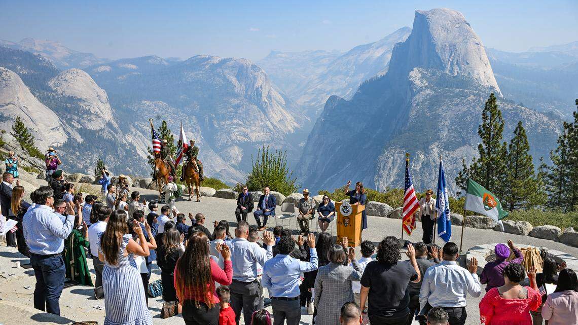 Citizen candidates raise their hands to take the Oath of Allegiance with Half Dome as a backdrop during a naturalization ceremony held at Glacier Point in Yosemite National Park to commemorate Constitution Day and Citizenship Day on Wednesday, Sept. 17, 2025.