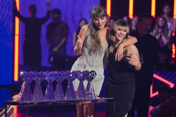 Alysa Liu, right, presents the artist of the year award to Taylor Swift during the IHeartRadio Music Awards on Thursday, March 26, 2026, at the Dolby Theatre in Los Angeles. (AP Photo/Chris Pizzello)