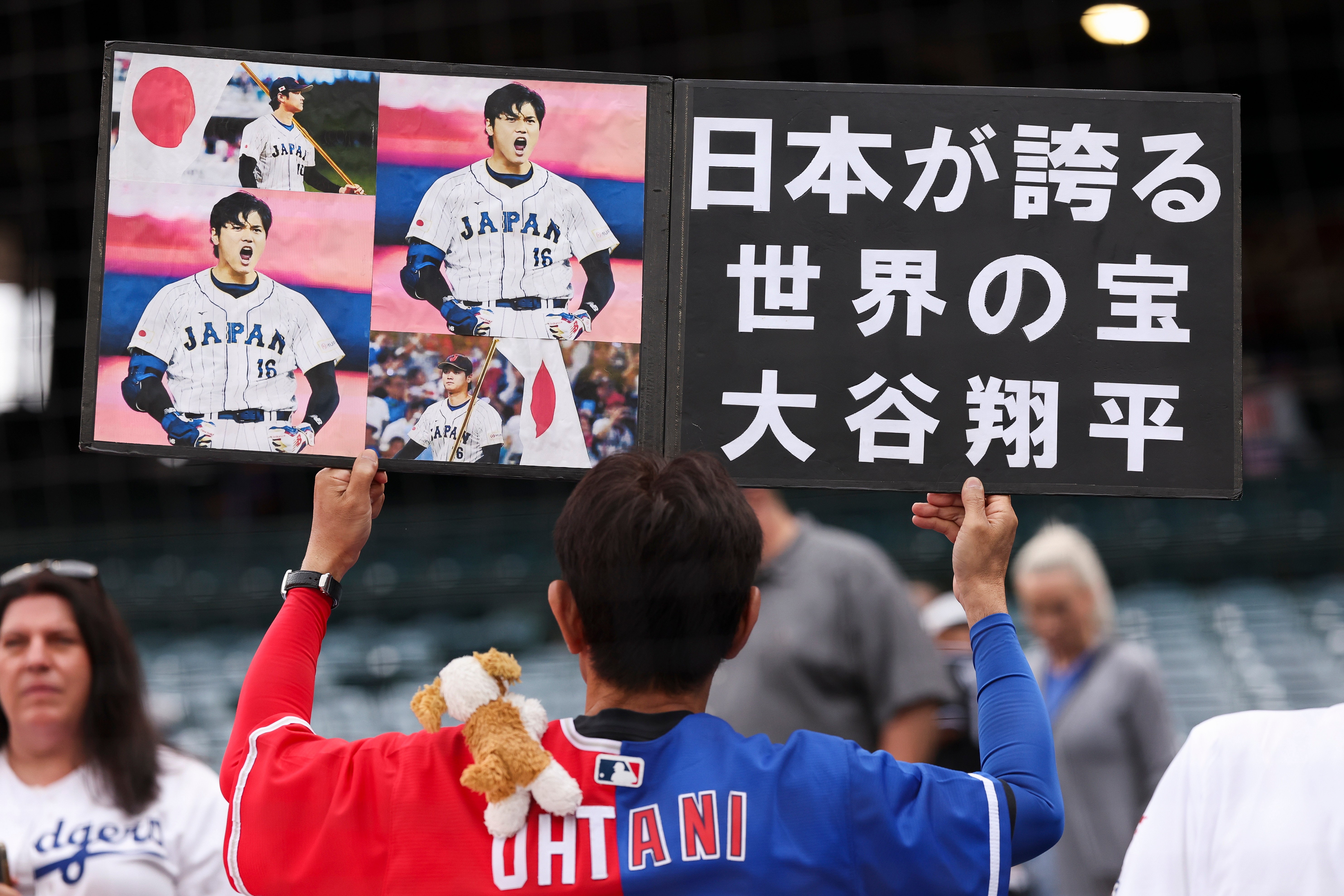 A fan holds up a sign for Dodgers’ Shohei Ohtani...