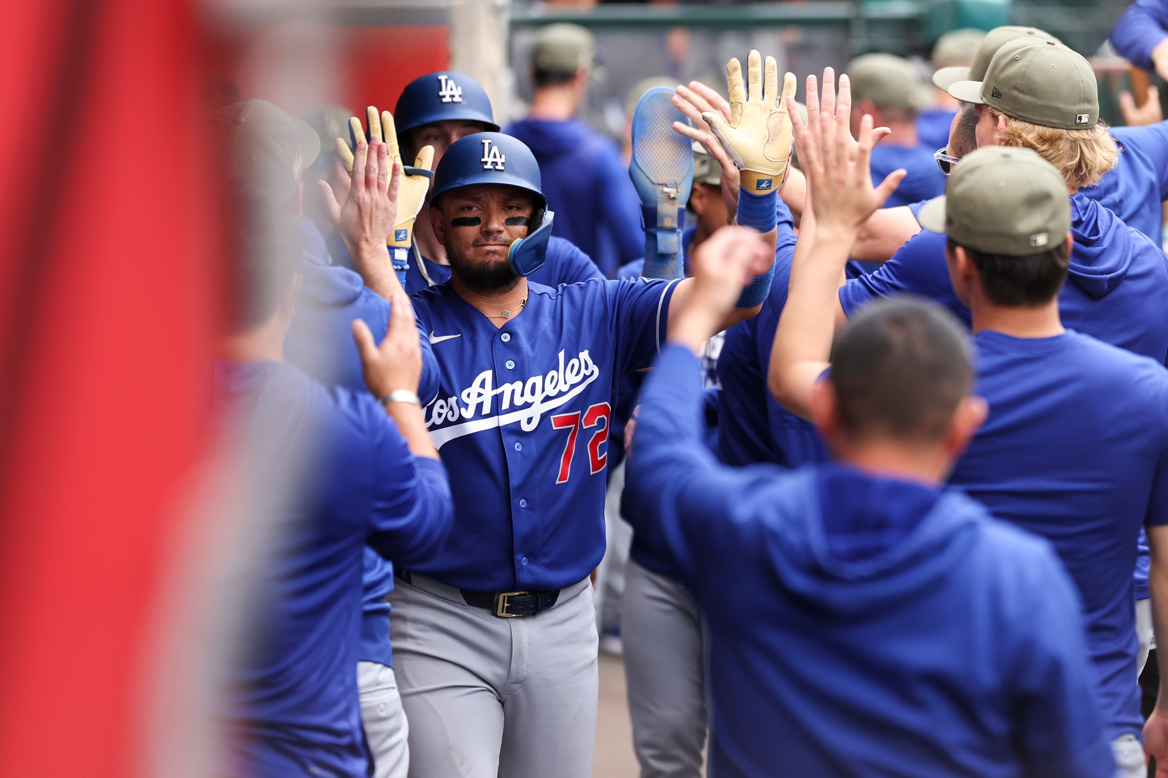 Dodgers’ Miguel Rojas celebrates in the dugout after a sacrifice...