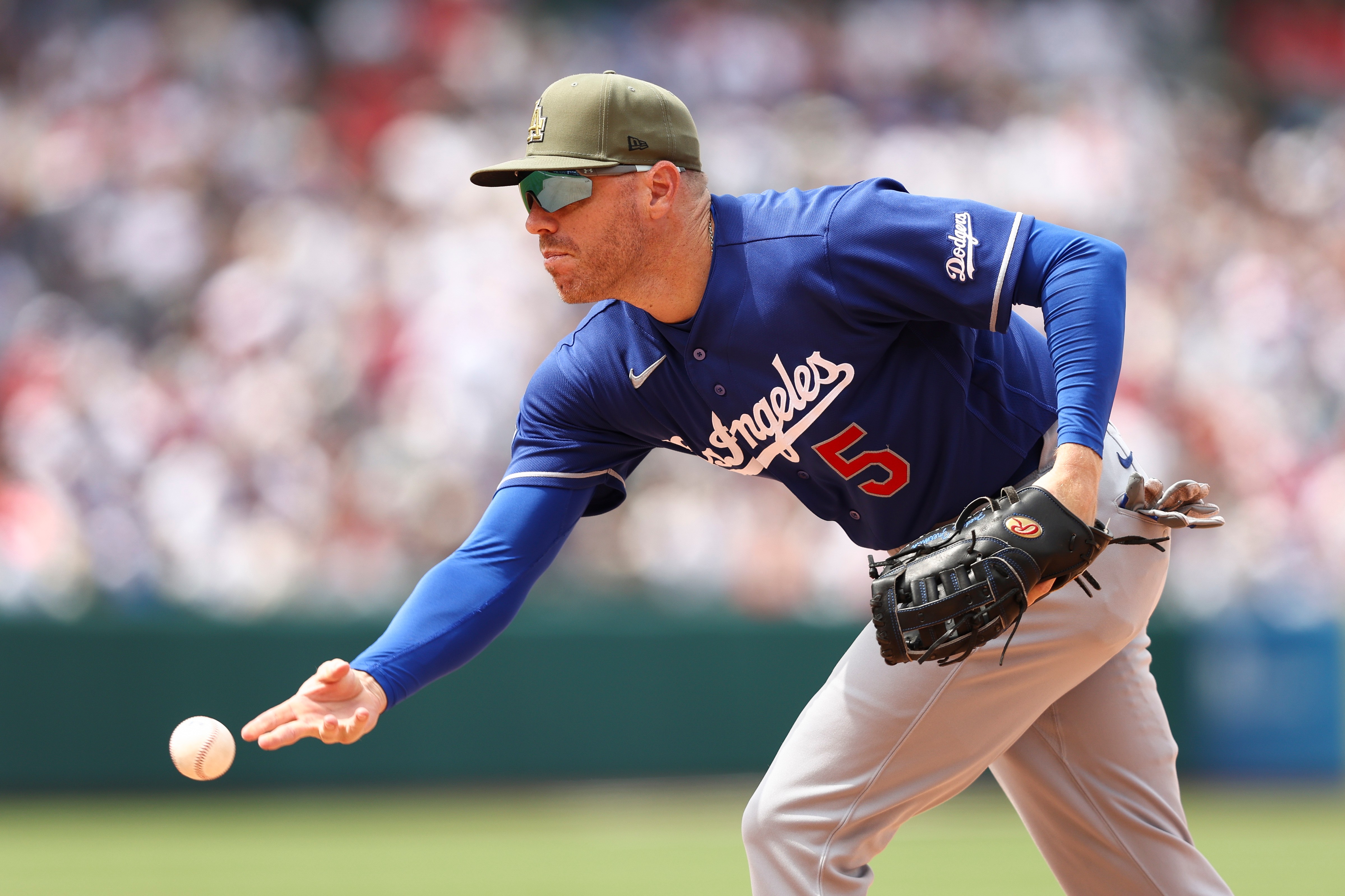 Dodgers first baseman Freddie Freeman tosses the ball to first...