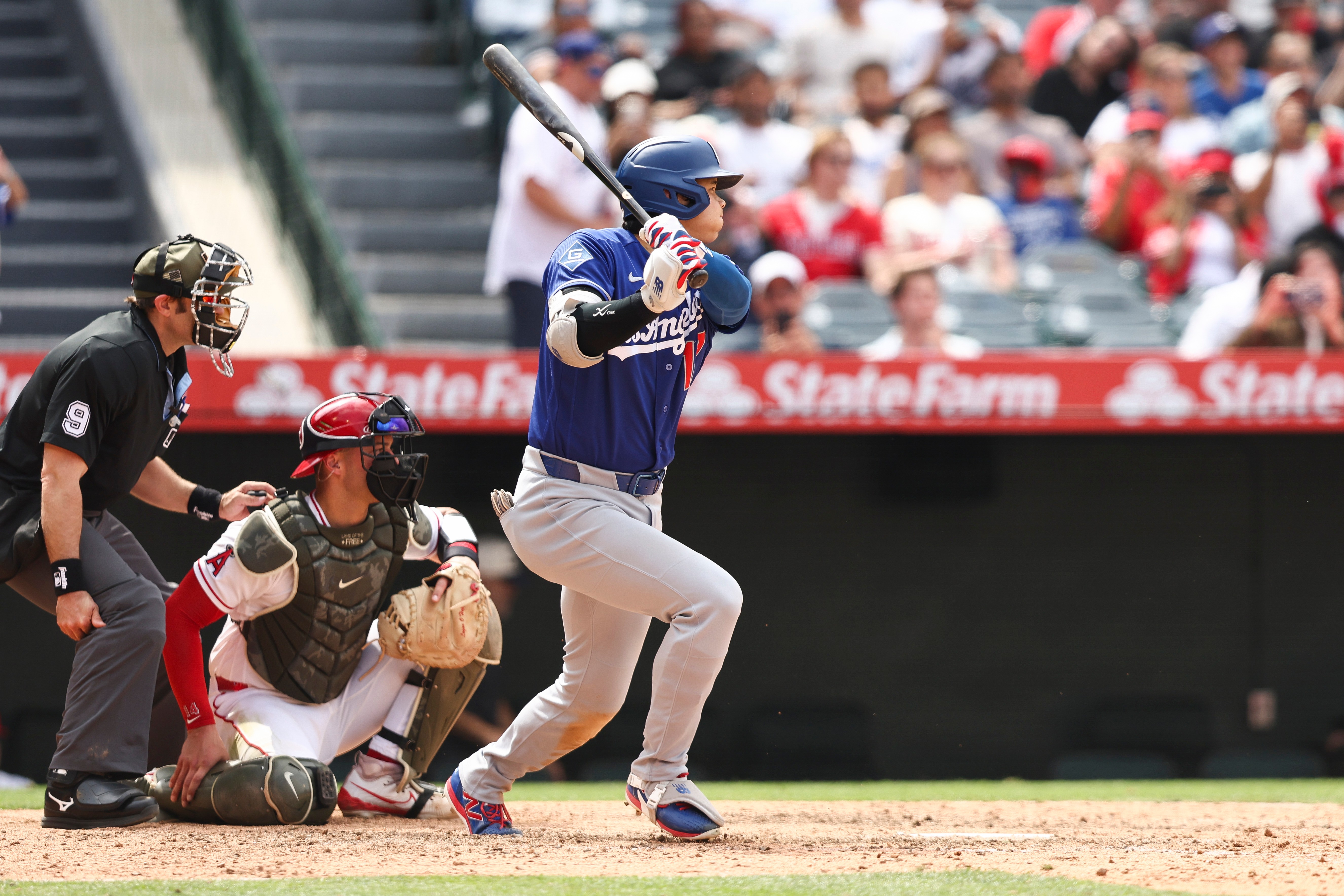 Dodgers’ Shohei Ohtani follows through on a single during the...