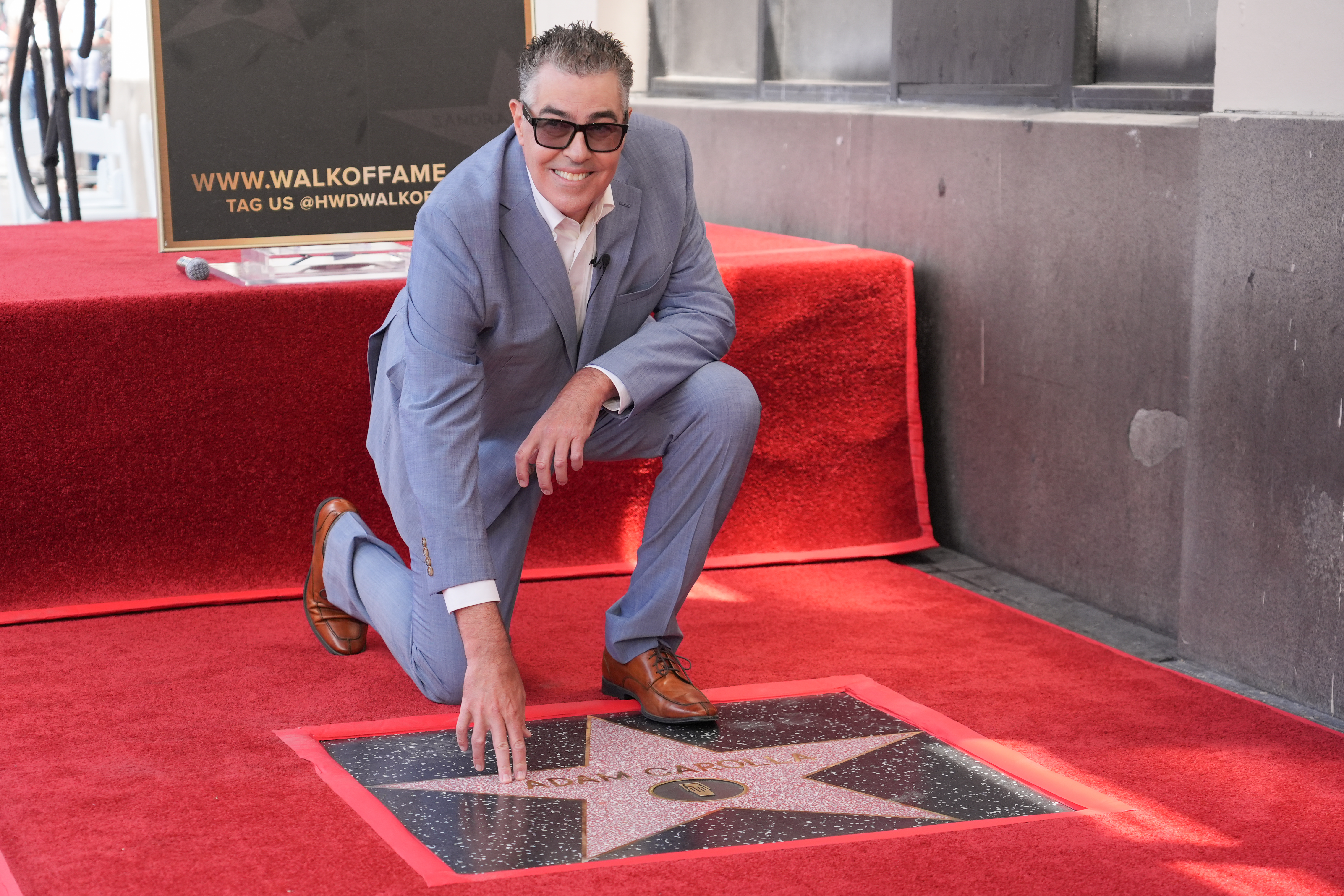 Adam Carolla poses with his new star during a ceremony...