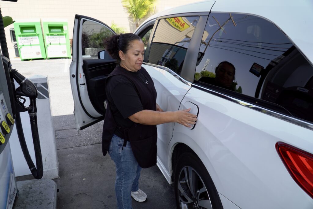 Veronica Cervantes, 54, of Compton, fills up her car at a Los Angeles gas station on April 30, 2026. She is one of many Californians dealing with skyrocketing gas prices that have continued to surge during the war in Iran. Credit: Steven Rodas/Inside Climate News