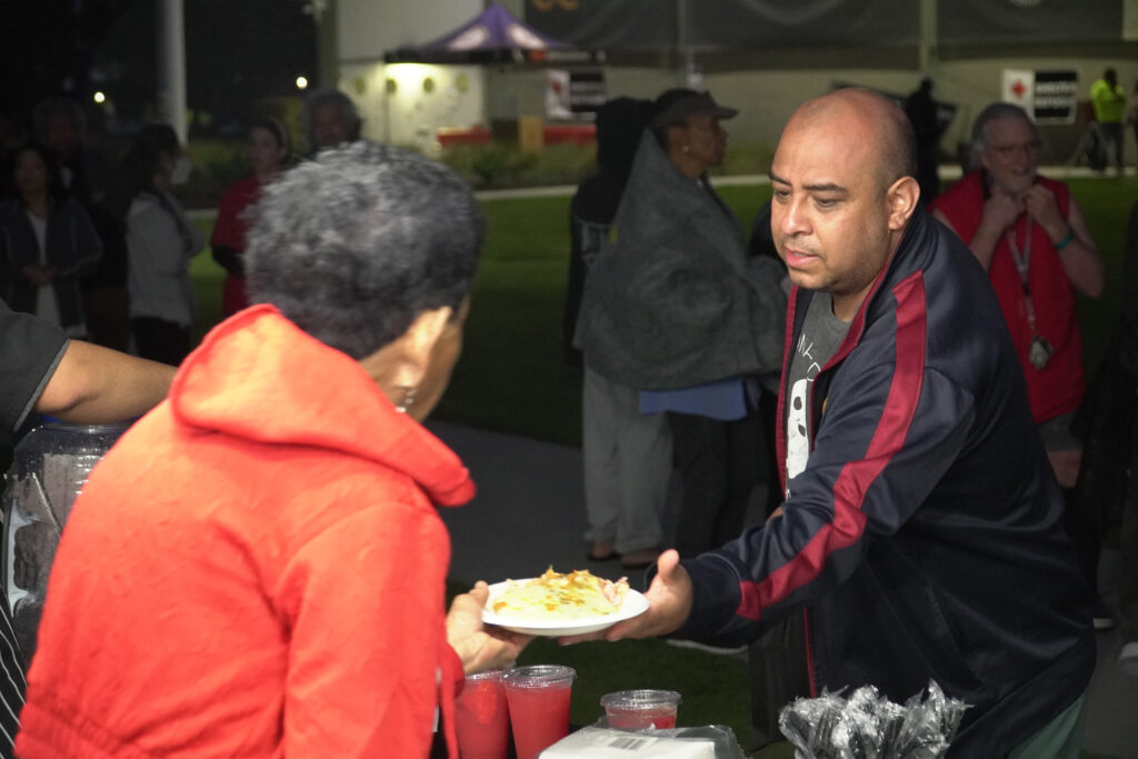 Residents line up for food on May 23 at a Fountain Valley shelter set up for families forced to evacuate. Credit: Steven Rodas/Inside Climate News