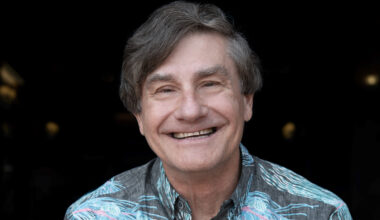a smiling man in a Hawaiian shirt