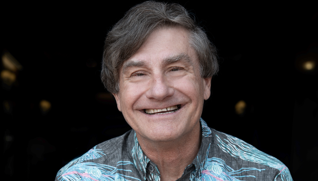 a smiling man in a Hawaiian shirt