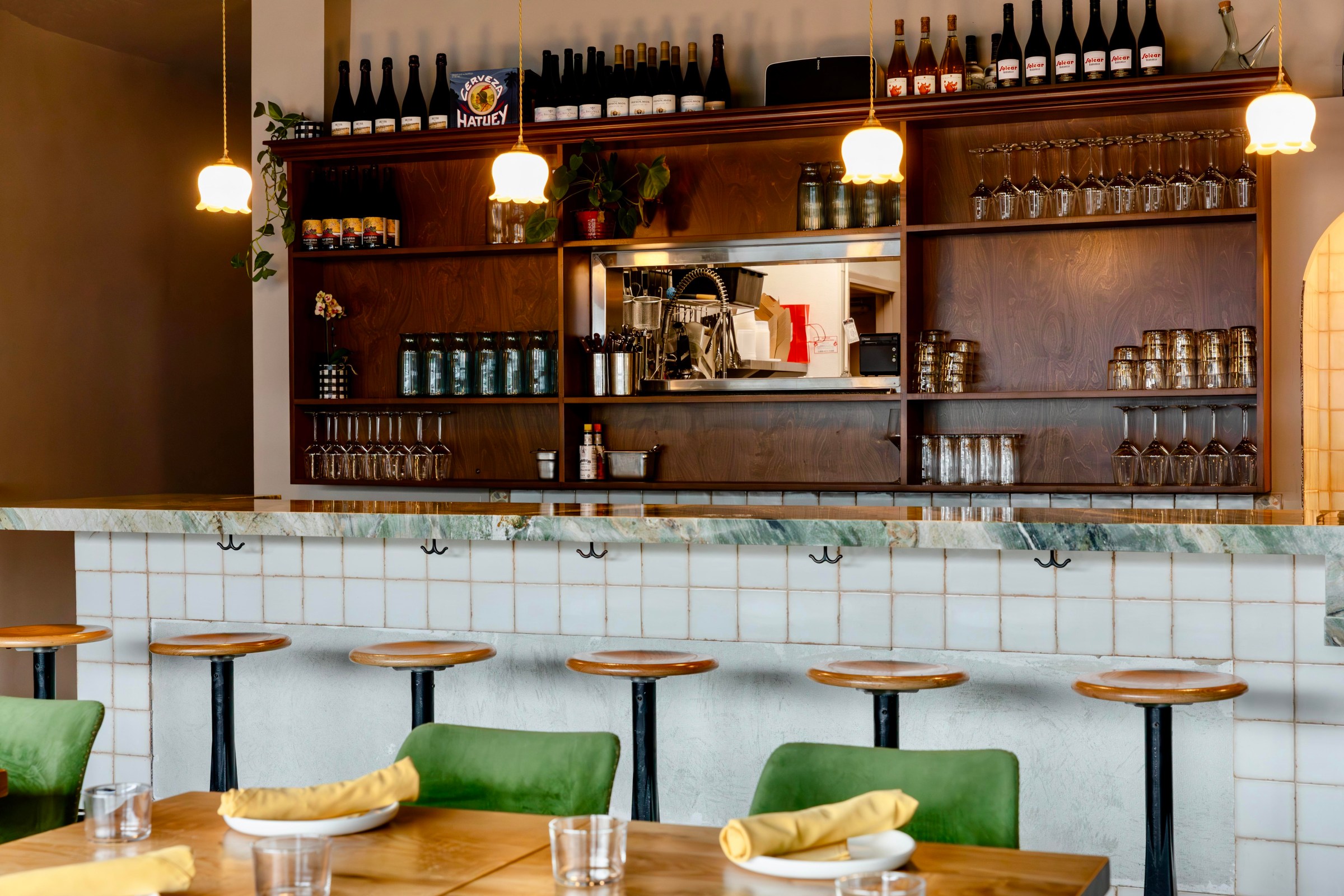Interior of Amiguita with wood tables and white bar.