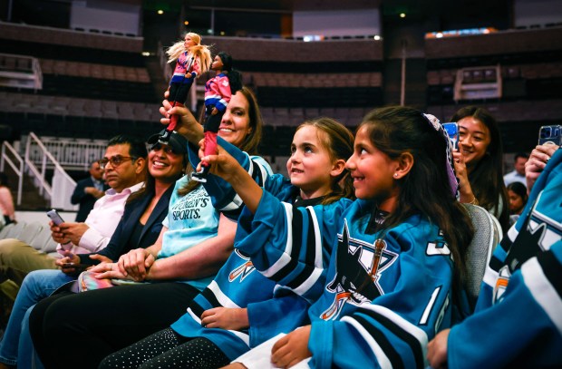 Mary Bowles, 8, of Santa Clara, left, and Meadow Patel, 8, of Los Gatos, both Jr. Sharks hockey players hold up hockey Barbie dolls during a press conference where Professional Women's Hockey League officially announces a team in San Jose at SAP Center in San Jose, Calif., on Tuesday, May 19, 2026. (Shae Hammond/Bay Area News Group)