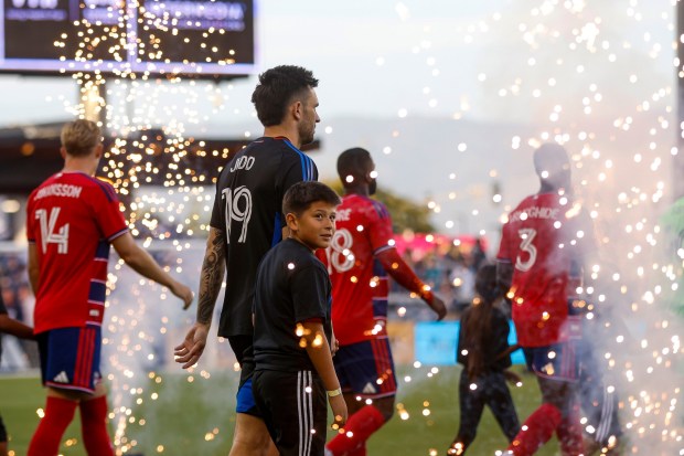 A young fan walks on the field with San Jose Earthquakes' Preston Judd (19) before a game against Dallas FC at PayPal Park in San Jose, Calif., on Saturday, May 16, 2026.  (Shae Hammond/Bay Area News Group)