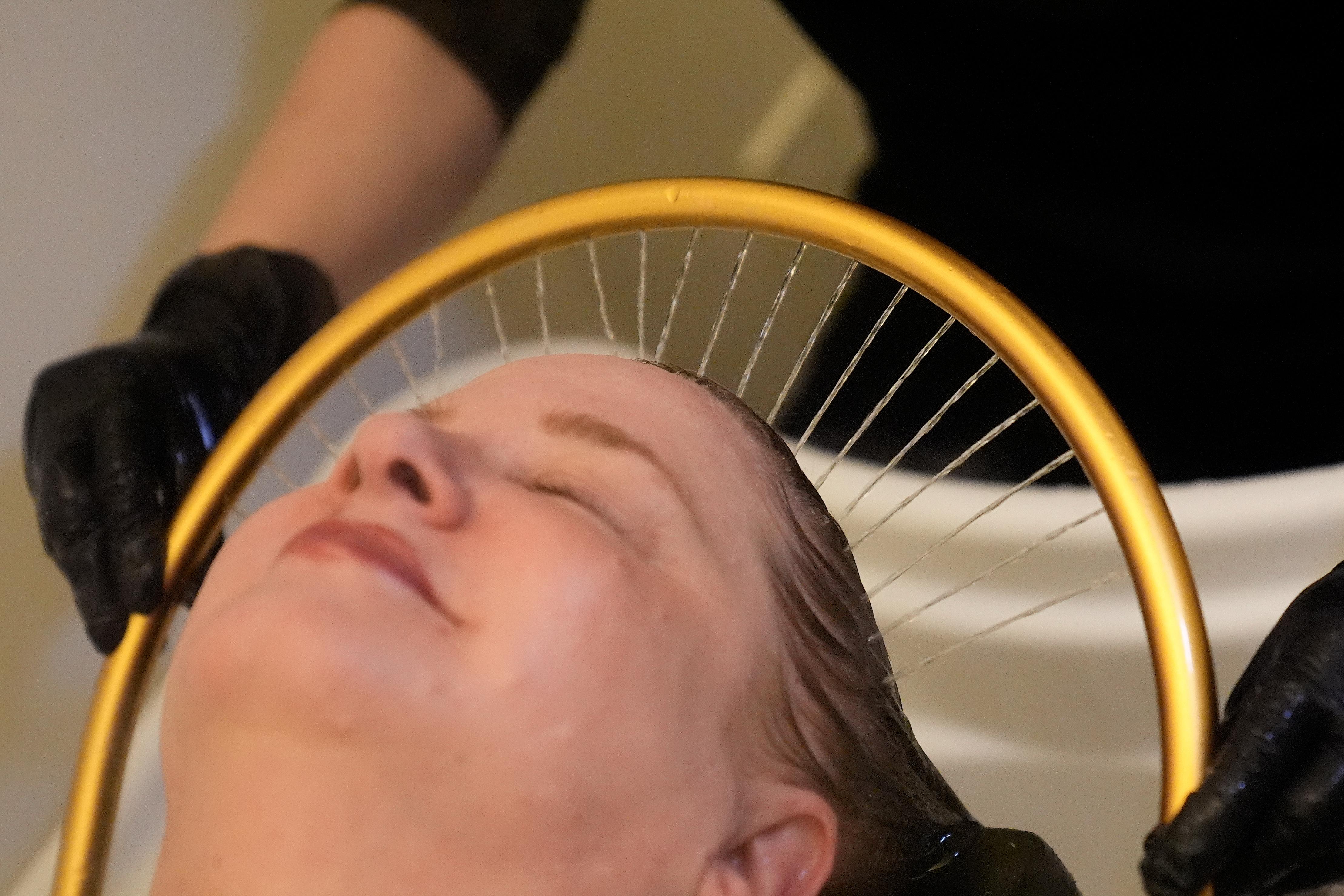 Head spa specialist Ha Truong, right, applies a halo waterfall...