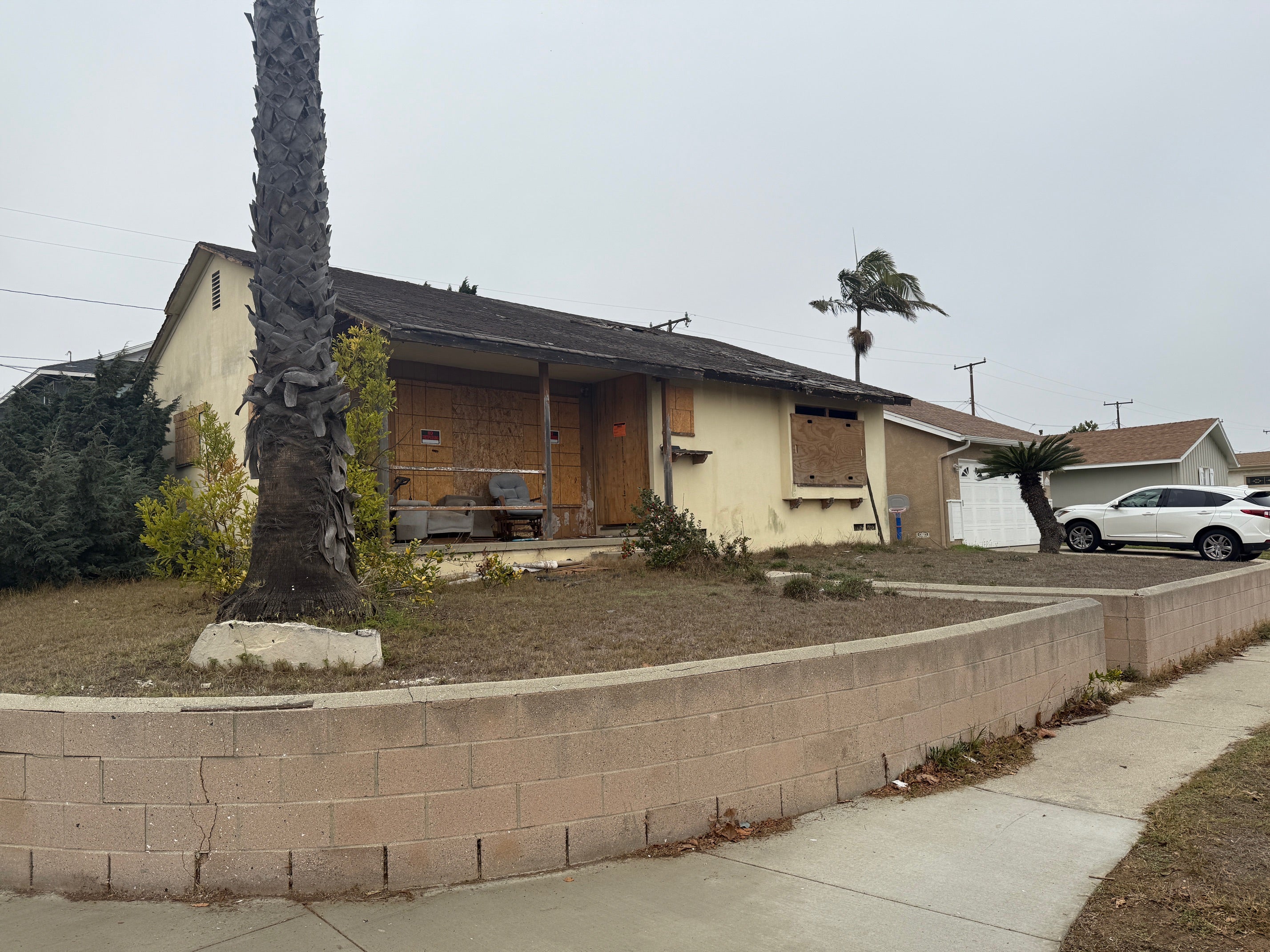 The house is clearly unlivable, with a gaping hole in the roof