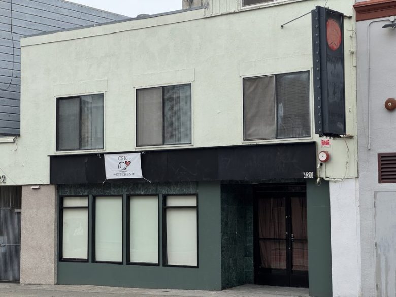 A two-story building with closed blinds on the ground floor and a small "CSK Naturopathy" sign above the entrance. An unlit vertical sign hangs on the right side.