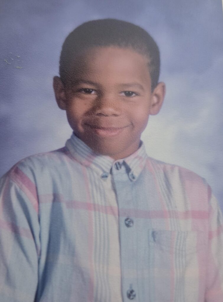 A faded picture from when Long was in elementary school, wearing a collared shirt. 