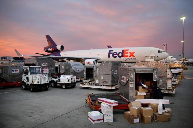 Brenda Thompson loads packages into a container at the FedEx hub.