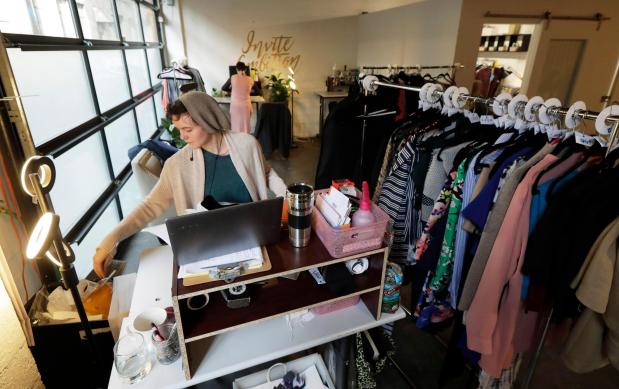 Madeline Smith packages clothing for shipments as she works for Armoire.