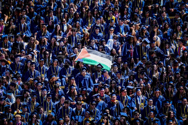 A Palestian flag is displayed between UC Berkeley undergraduate and graduate students of the Class of 2026 during their commencement ceremony at California Memorial Stadium in Berkeley, Calif., Saturday, May 16, 2026. (Ray Chavez/Bay Area News Group)