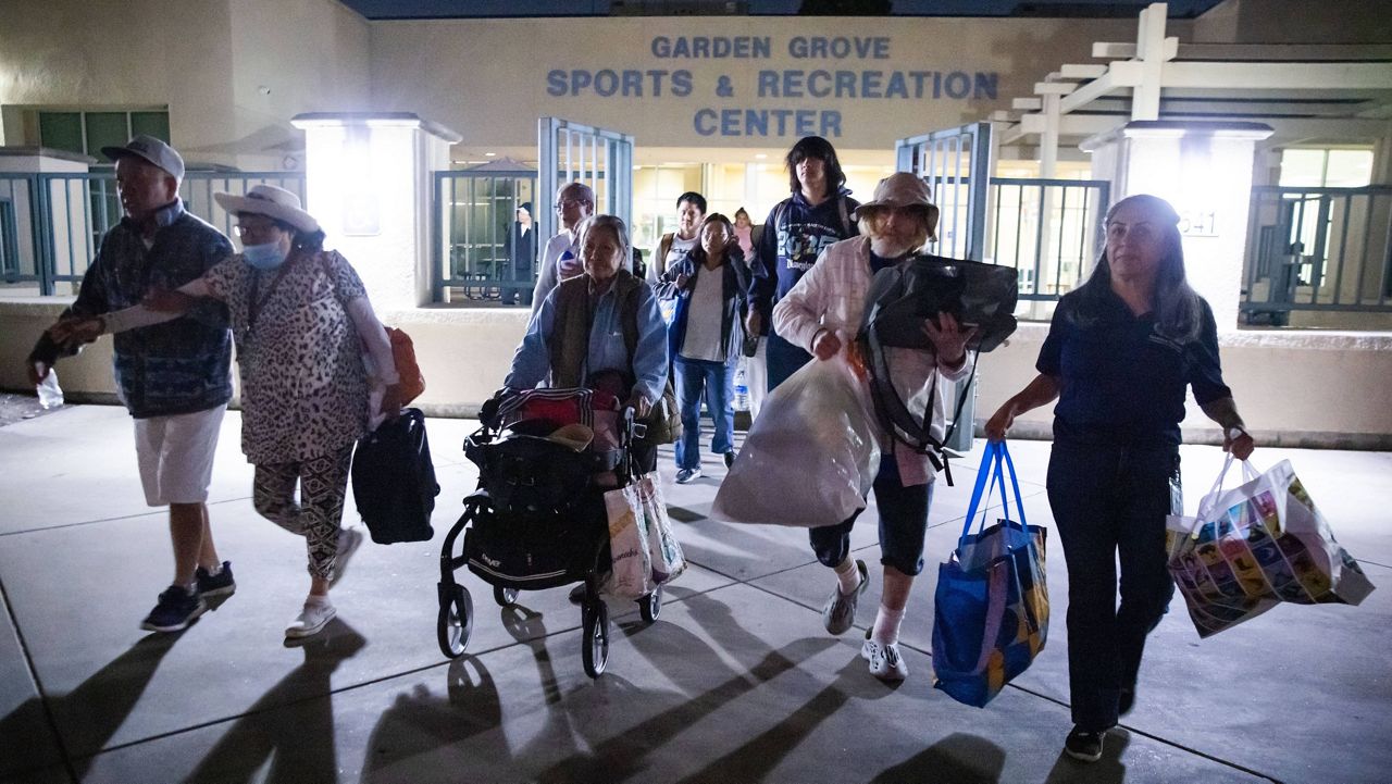 Evacuees from an aerospace chemical plant tank leak move to another shelter after the Garden Grove Sports and Recreation Center closed for the night in Garden Grove, Calif., Friday, May 22, 2026. (AP Photo/Ethan Swope)