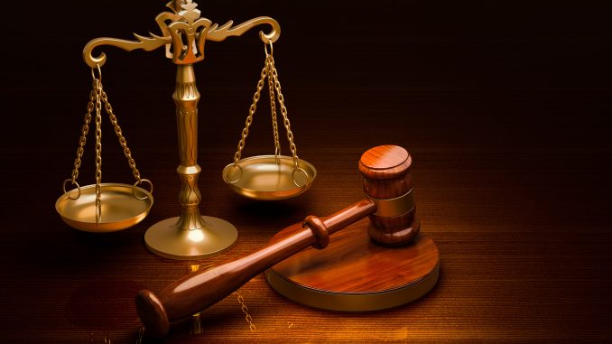 Scales of Justice and Wooden Gavel on the desk, 3D rendering