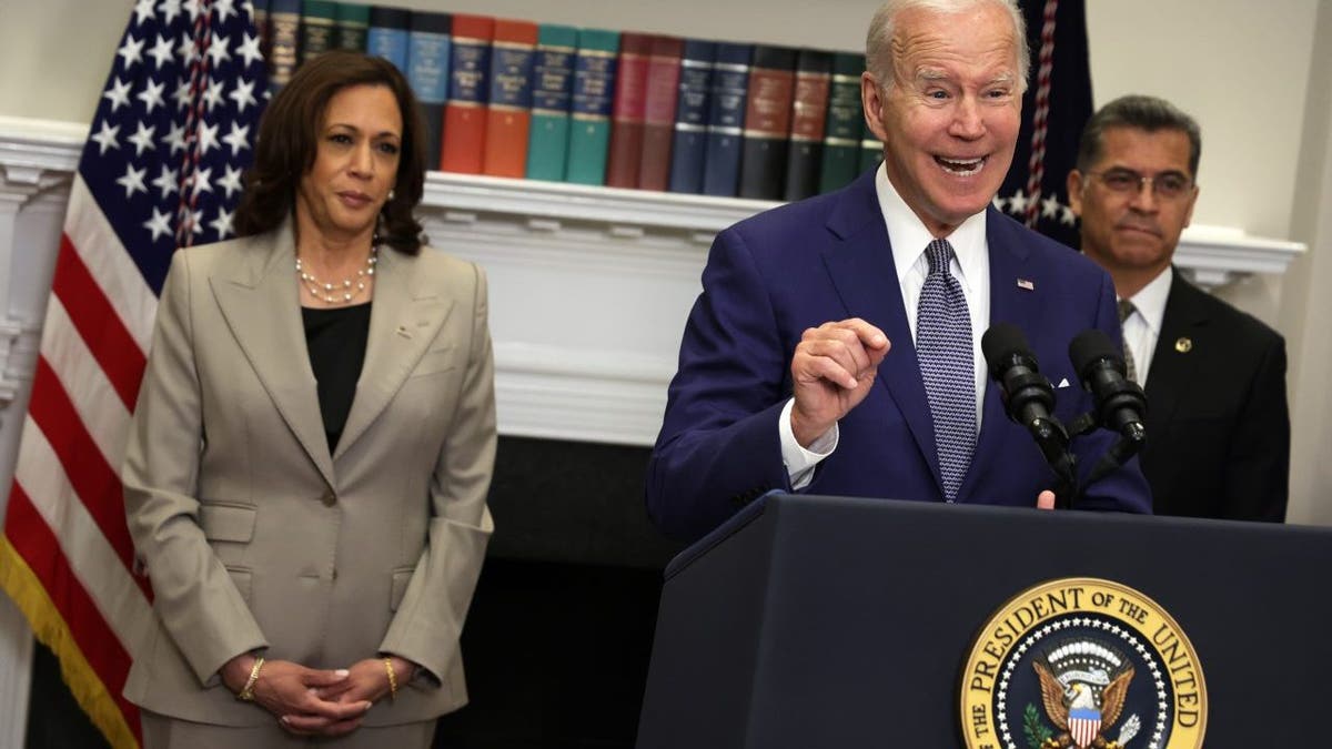 President Joe Biden speaking with Vice President Kamala Harris and Secretary Xavier Becerra listening in the Roosevelt Room