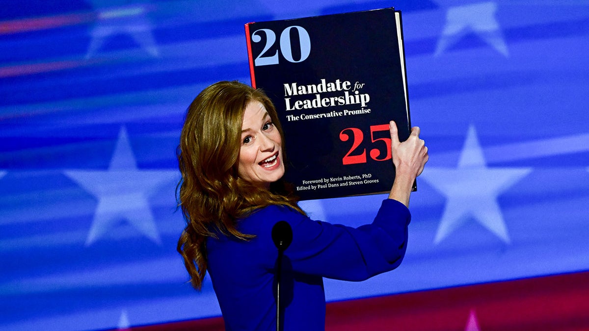 State Senator Mallory McMorrow holding up a Project 2025 book at the Democratic National Convention in Chicago
