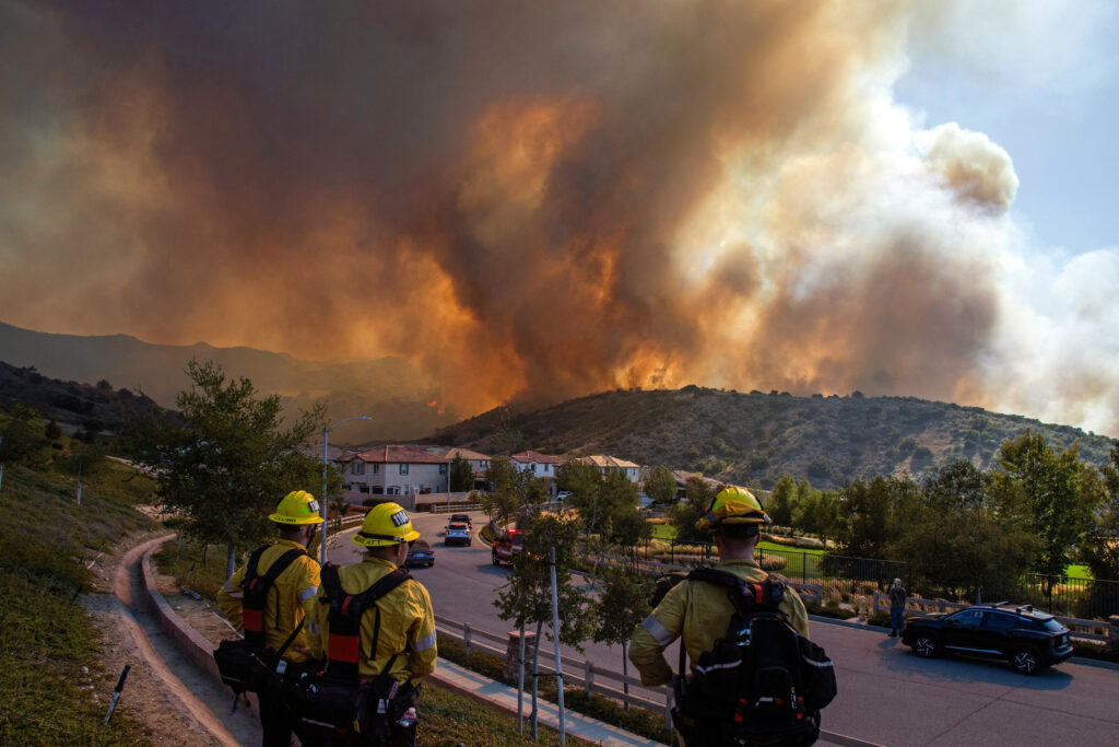 Firefighters monitor the Sandy Fire as it burns close to a residential area on Monday in Simi Valley, Calif. Credit: Apu Gomes/AFP via Getty Images