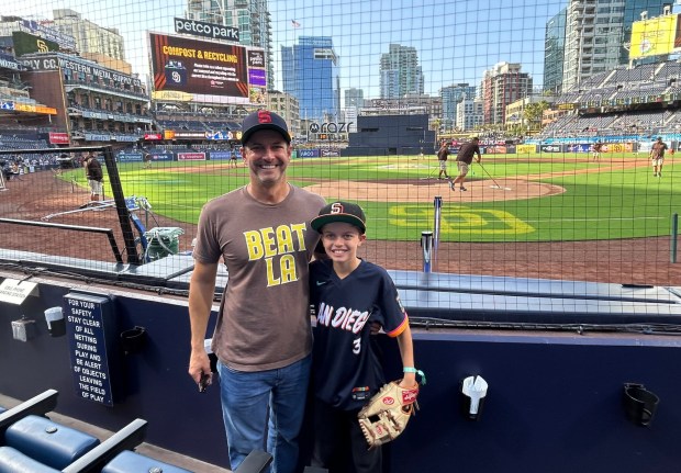 Aaron Hurvitz and his son Oliver found a creative way to coax a baseball from the Dodgers' Hyeseong Kim. (Kirk Kenney / San Diego Union-Tribune)