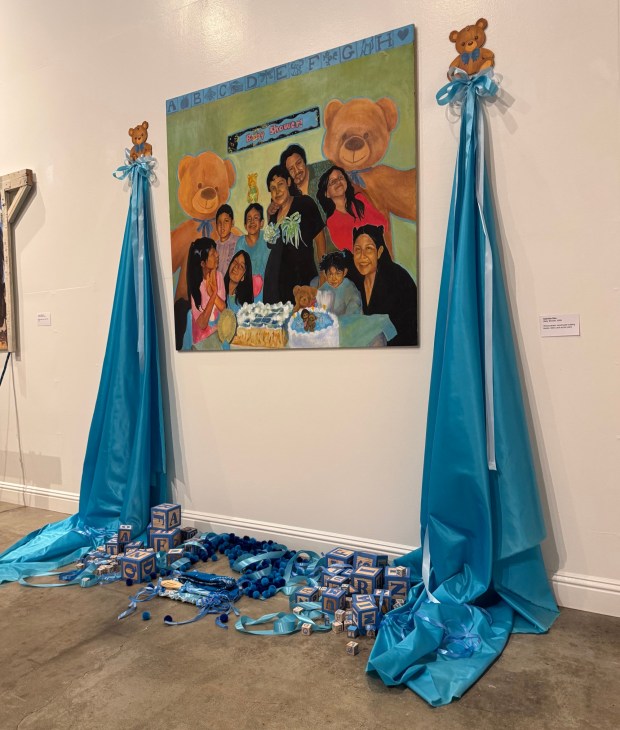 "The Baby Shower" by Gabriela Diaz occupies wall space and also floor space, with wooden alphabet blocks and other mock gifts, at the Millard Sheets Art Center at the L.A. County Fair. (Photo by David Allen, Inland Valley Daily Bulletin/SCNG)