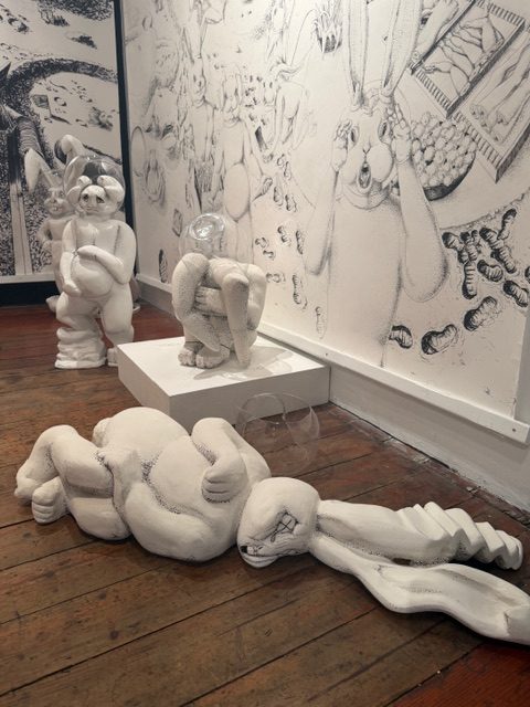 Galactic Nature sculptures of abstract human figures on gallery floor with illustrated wall backdrop