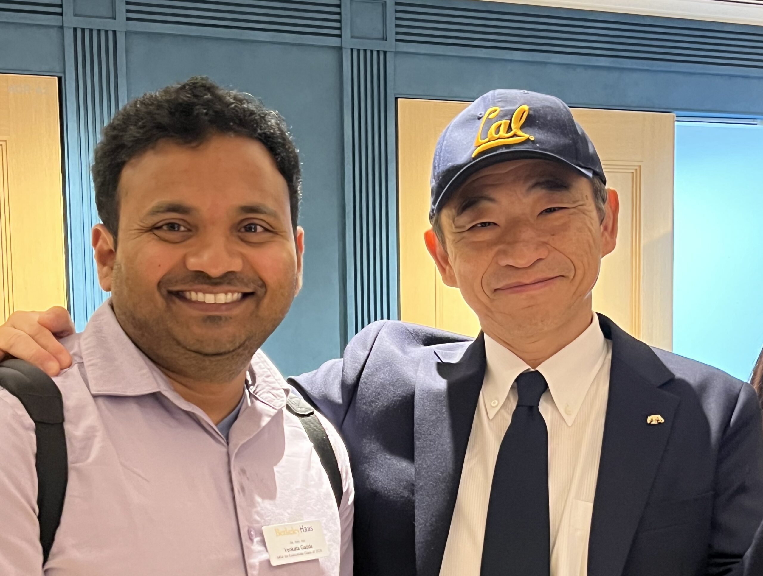 two men, one wearing a Cal cap and tie
