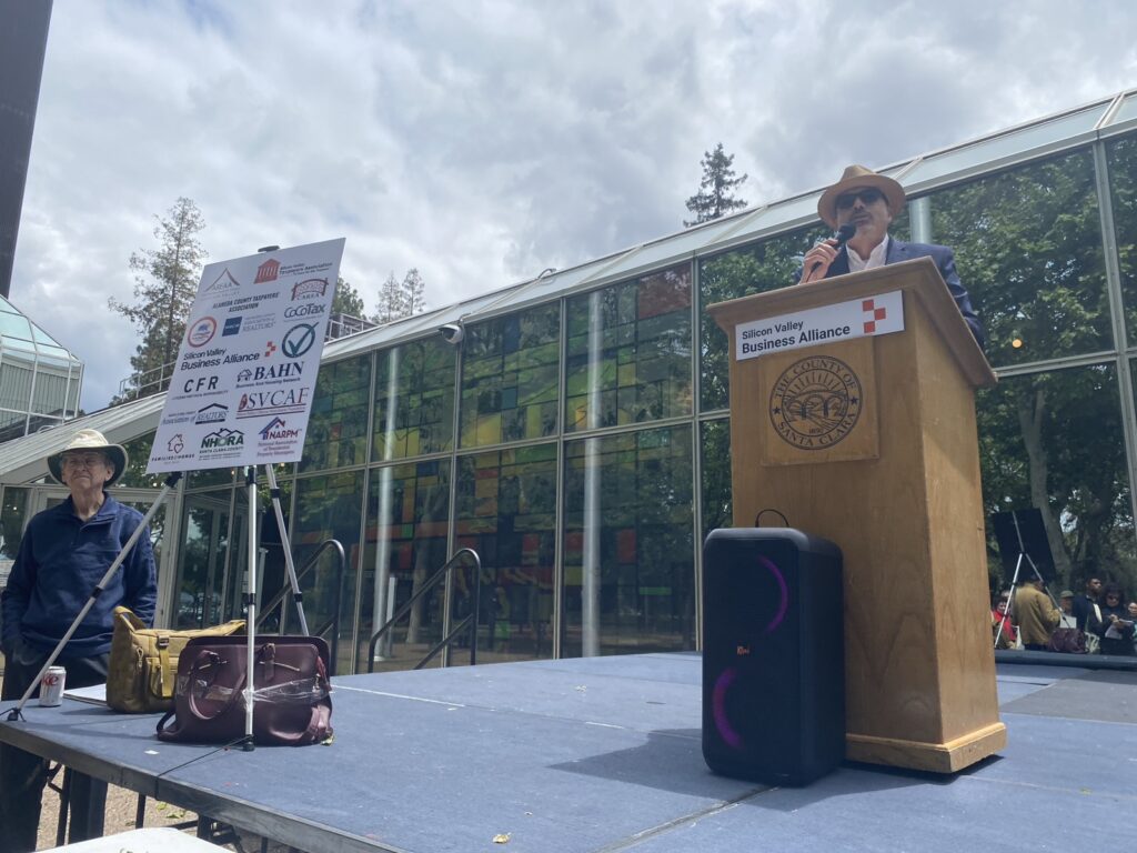 A man stands behind a podium