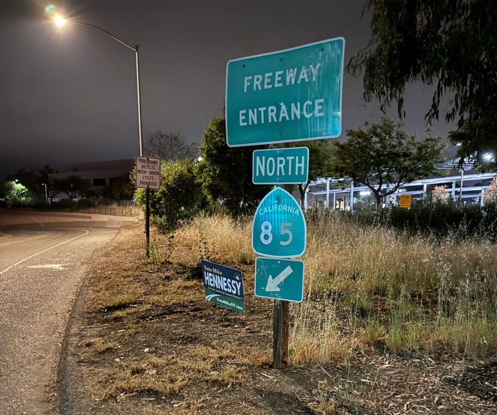 A sign placed on a grassy field.