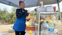 Abigal Castillo prepares one of her fresh fruit cups to sell at the entrance of the Tijuana River Valley Regional Park, May 16, 2026.