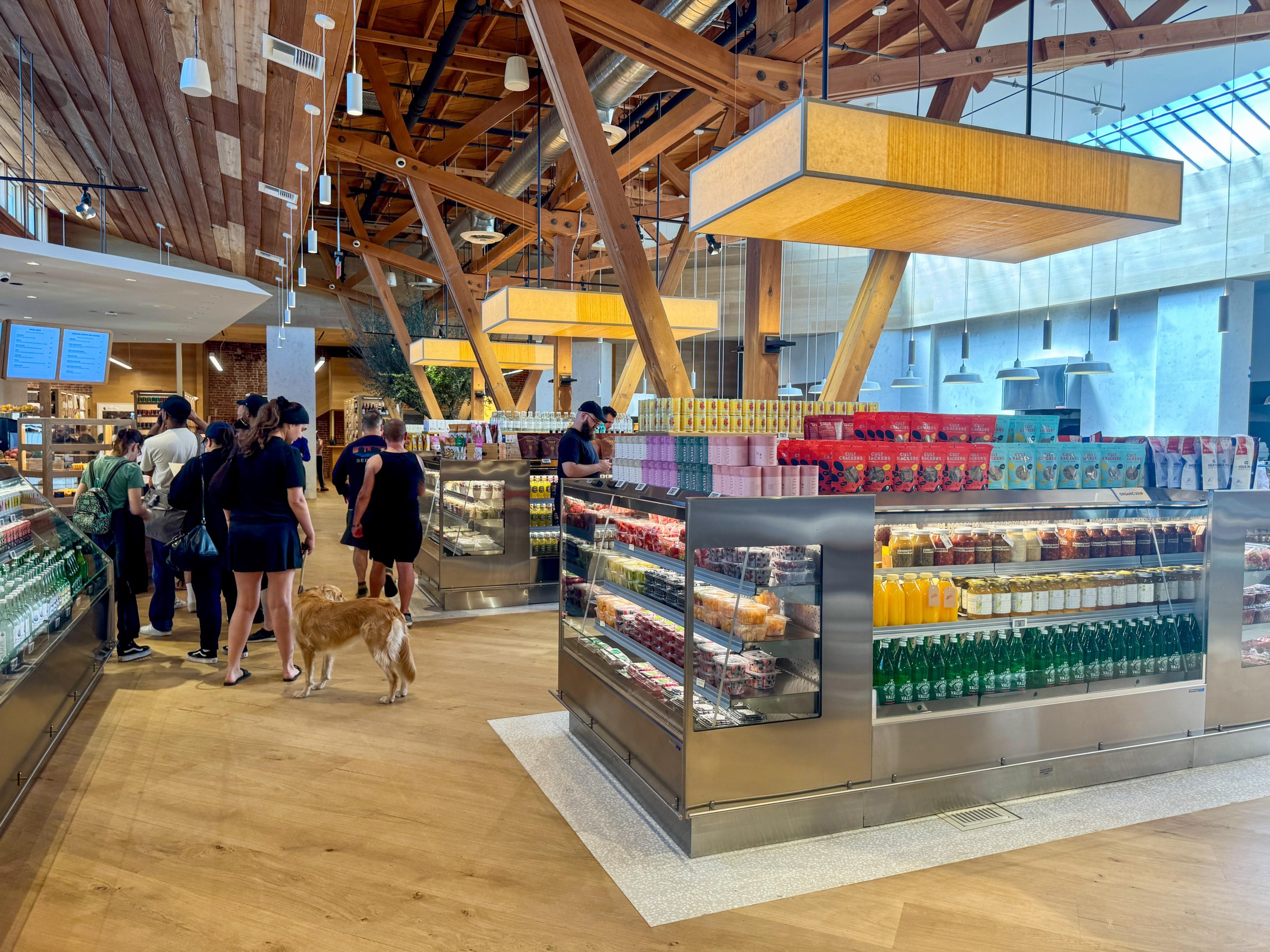 Interior of Laurel Supply with refrigerated cases and a group waiting in line.