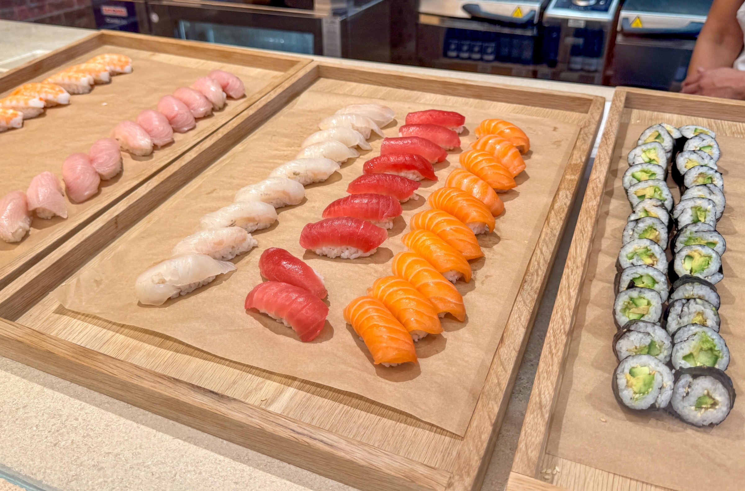 Rows of nigiri on wooden cutting boards at Laurel Supply.