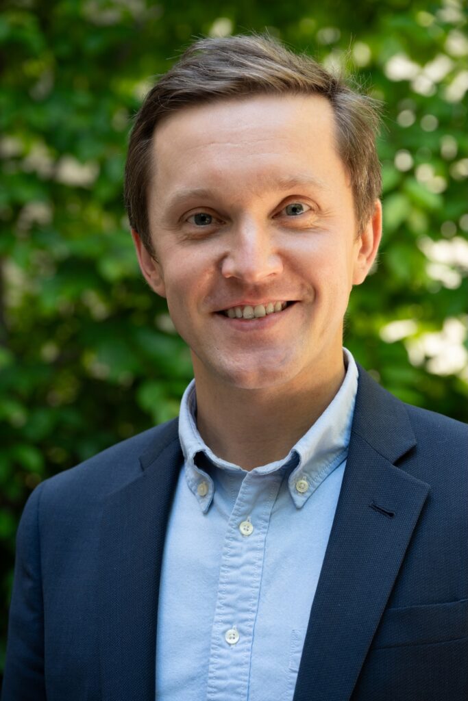 A headshot of Igor Chirikov in a blue collared shirt and blue blazer. 