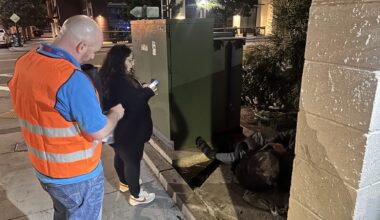 Two County employees speak with a person experiencing homelessness in the early morning hours.