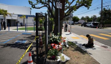 Nicole Witherow prays beside flowers placed outside of the Islamic Center of San Diego, a day after a shooting, Tuesday, May 19, 2026, in San Diego. (AP Photo/Jae C. Hong)