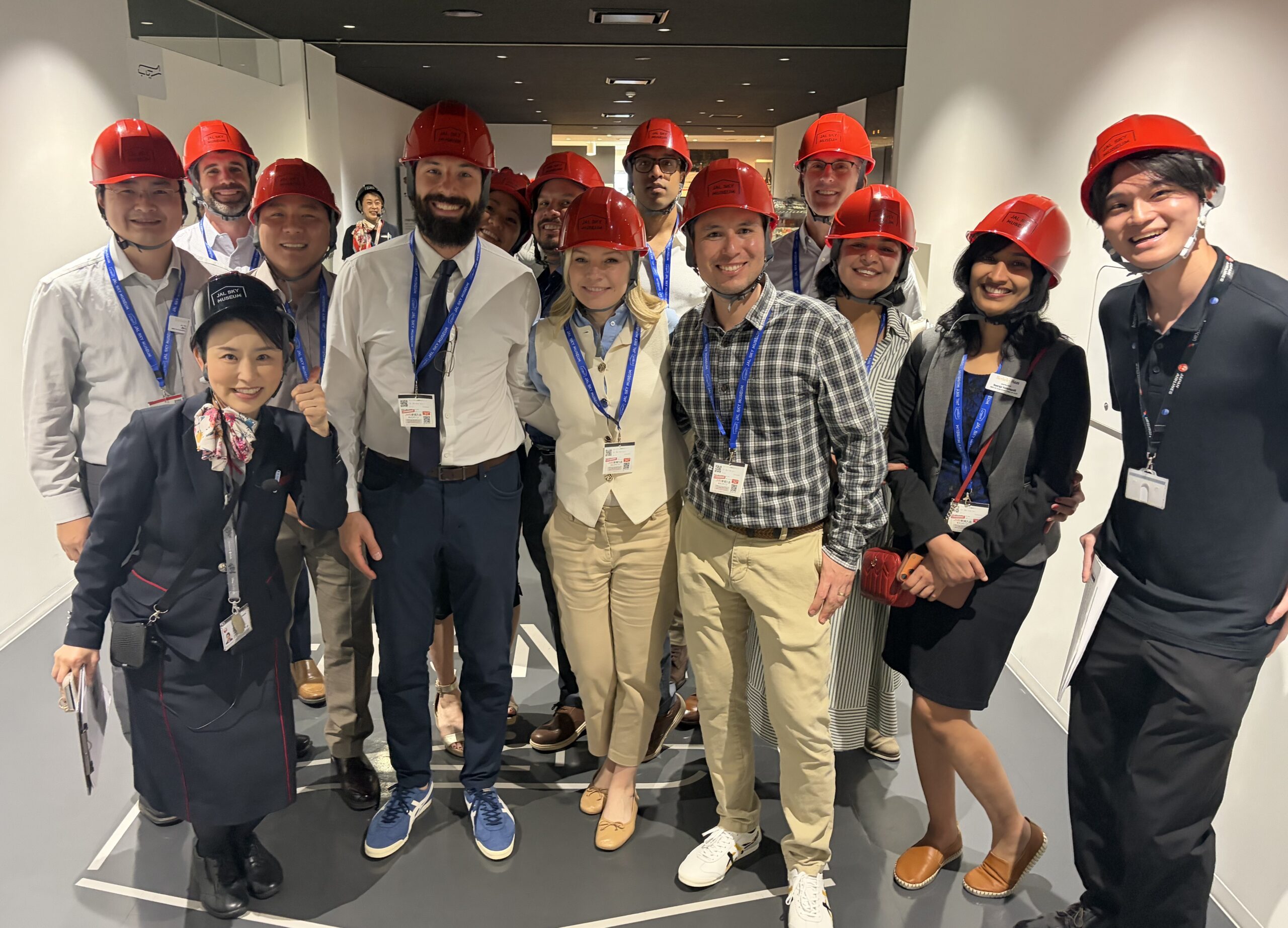 group of men and women in red helmets