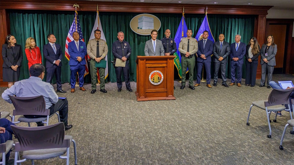 Los Angeles County officials and law enforcement leaders stand during a news conference about organized residential burglaries.