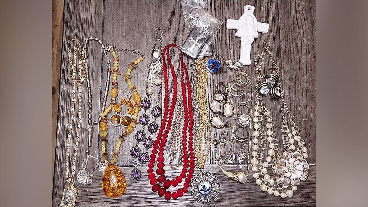 Assorted necklaces, rings, earrings and jewelry laid out on a table as evidence in a burglary investigation.