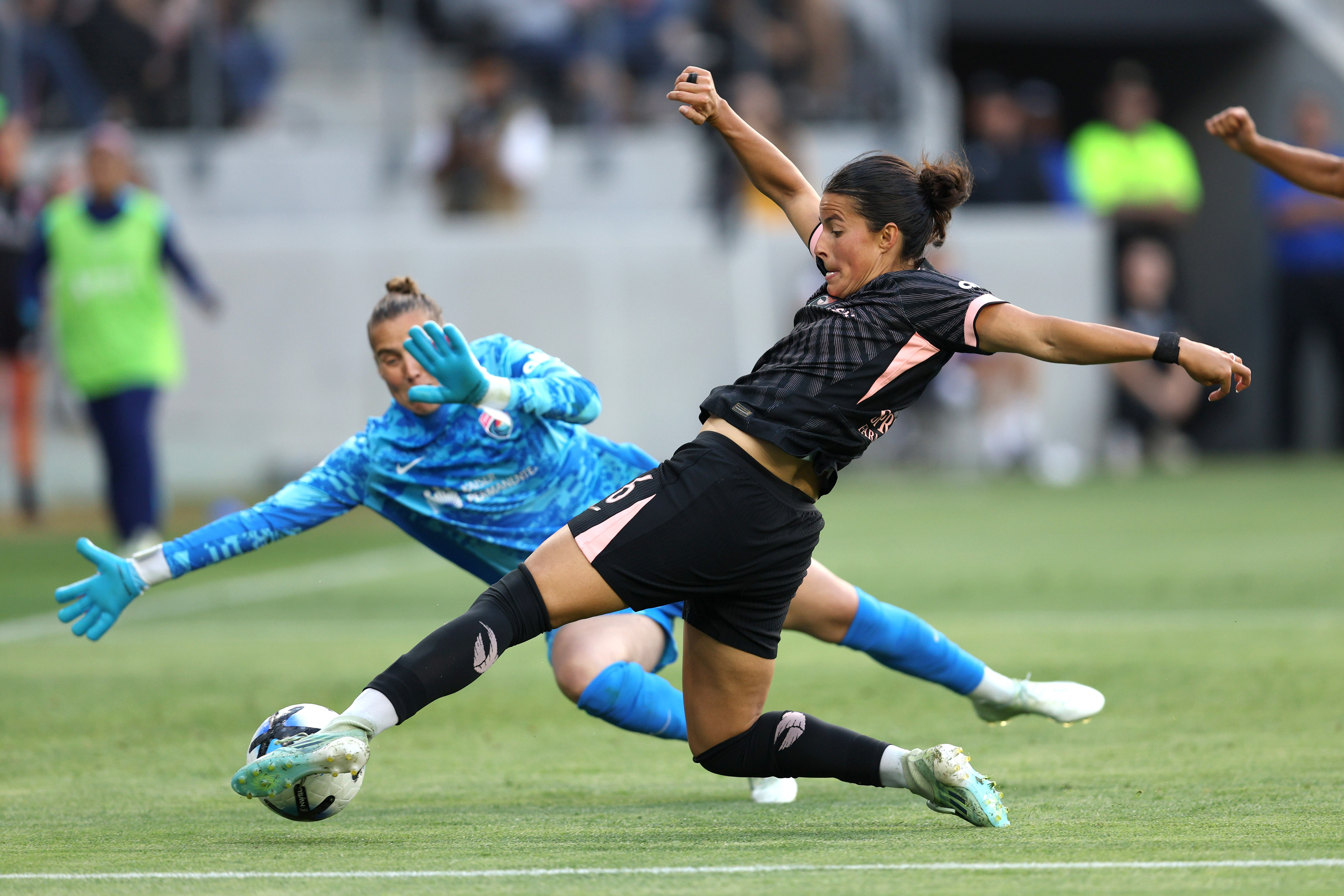 Angel City FC defender Emily Sams, front, kicks the ball...