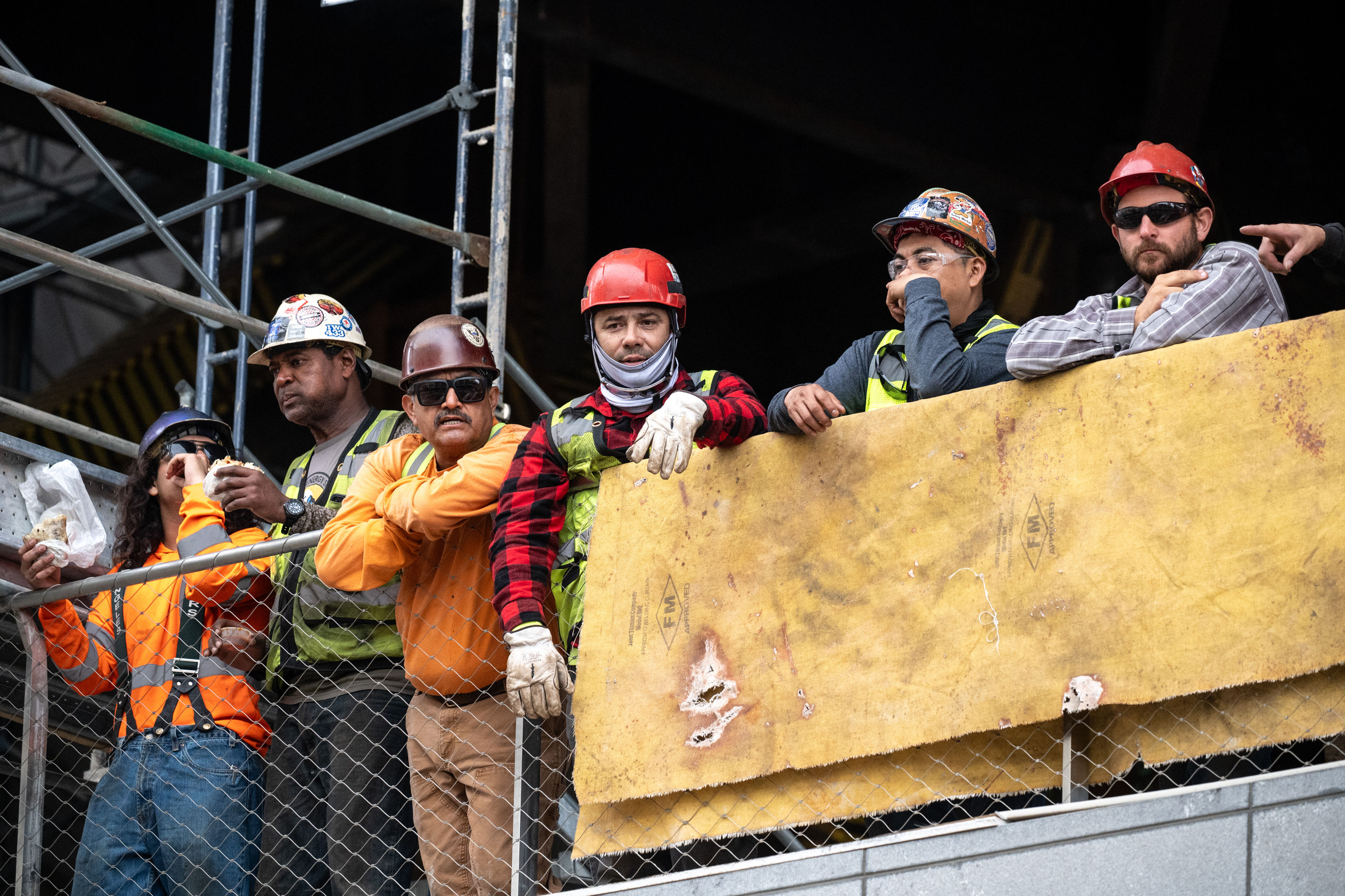 Workers look on as they wait for the last steel...