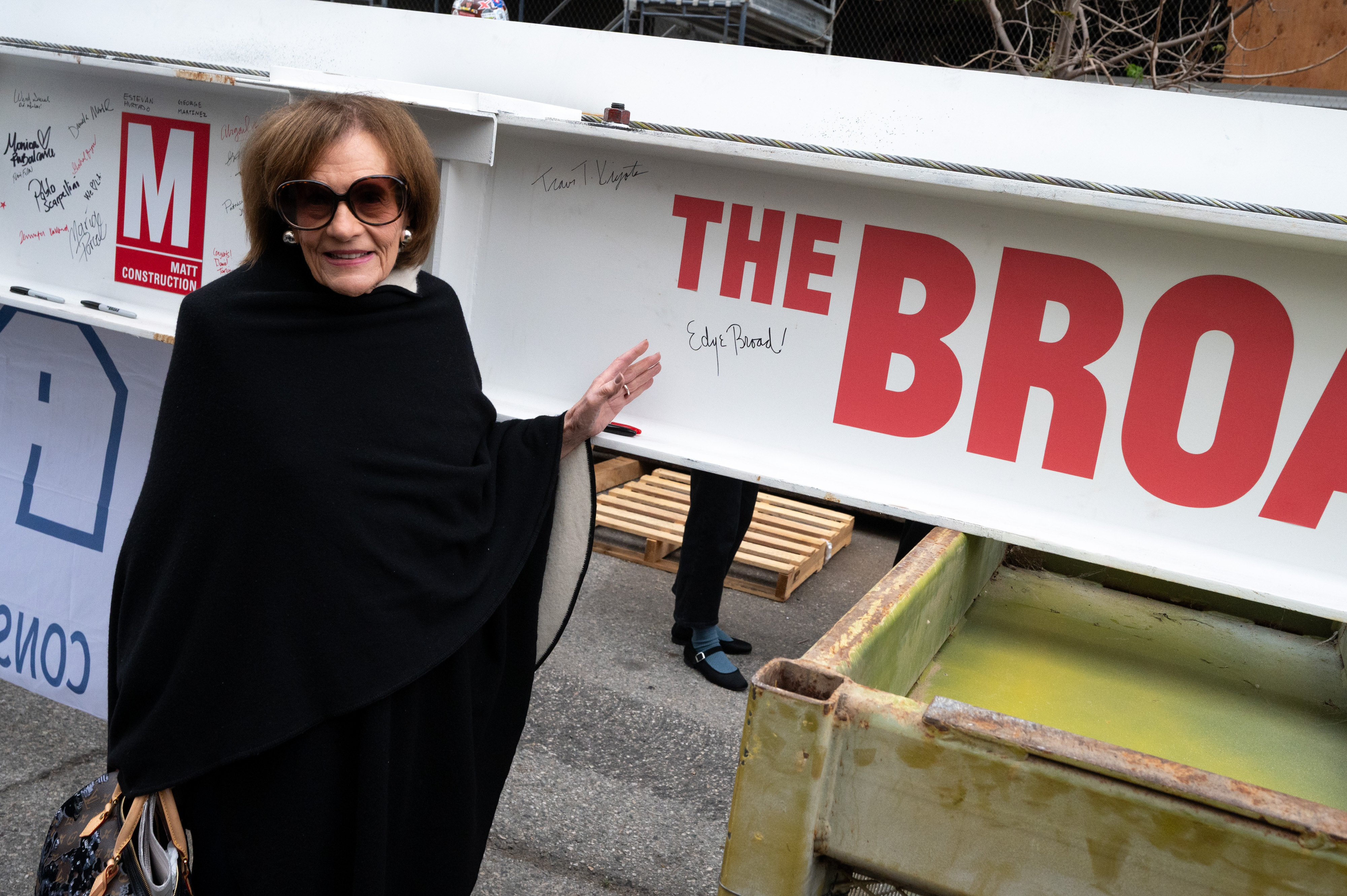 Edye Broad signs her name to the last steel beam...