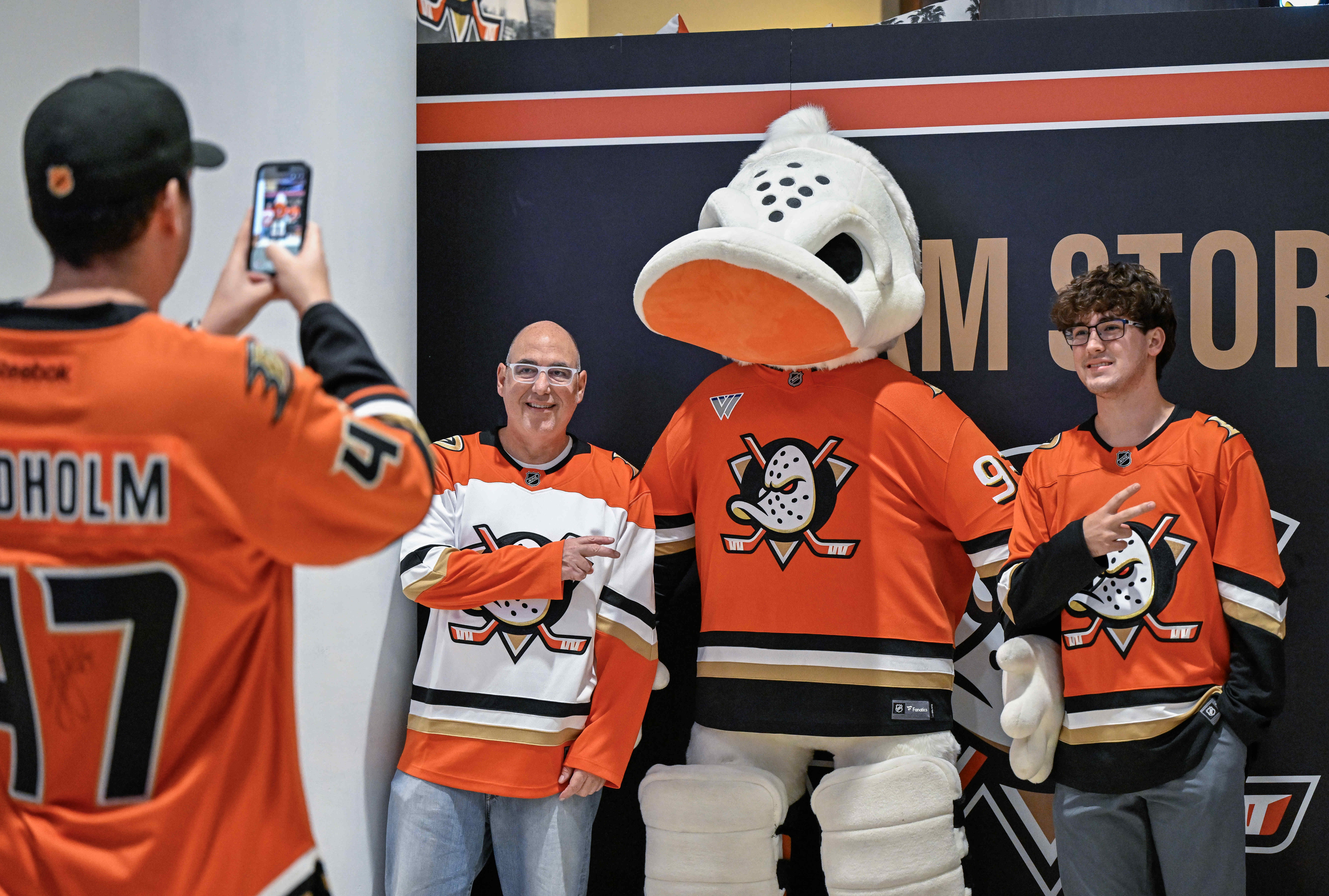 Fans pose for photos with a stuffed Wild Wing mascot...