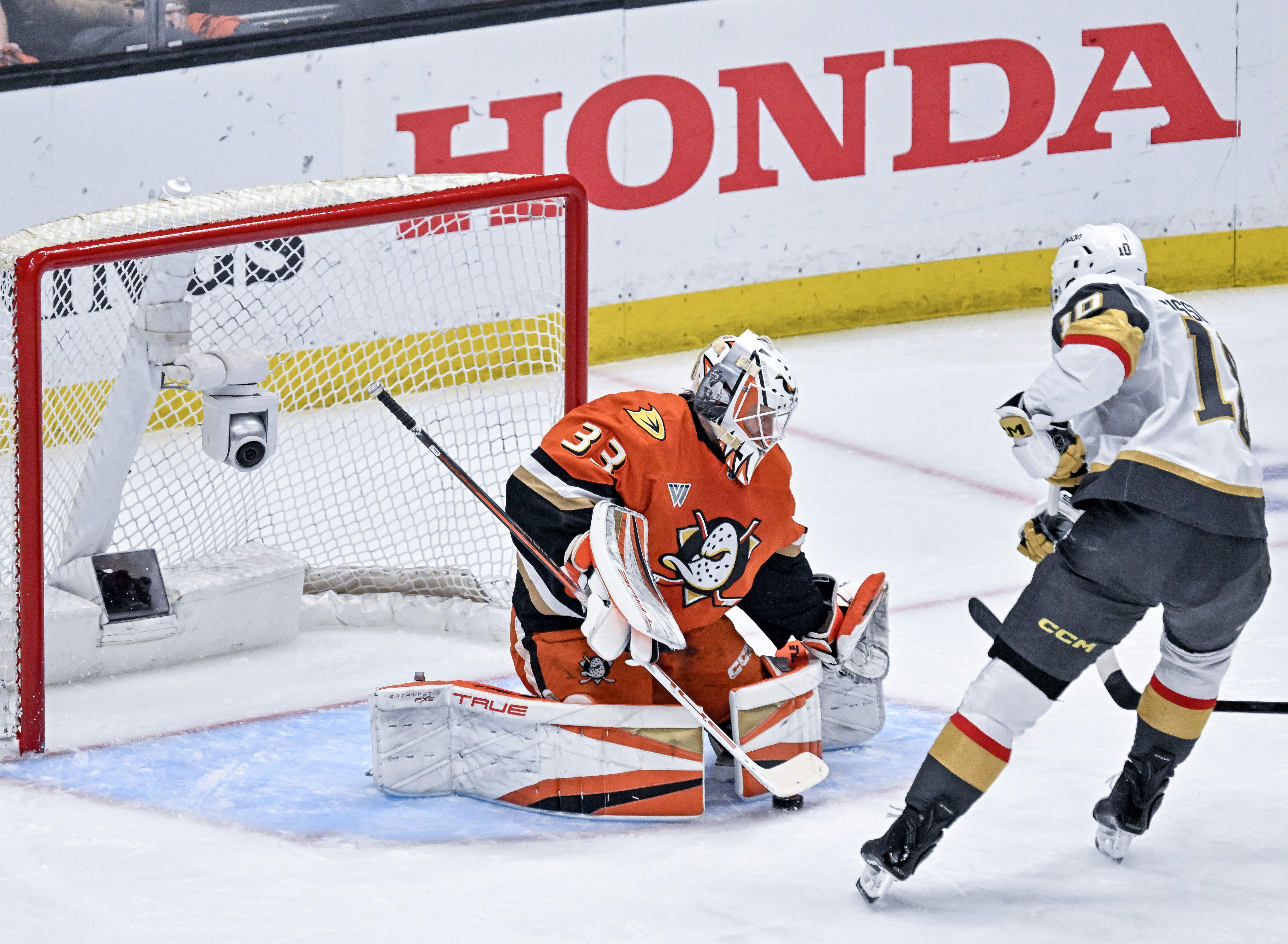 Ducks goaltender Ville Husso, left, blocks a shot by the...