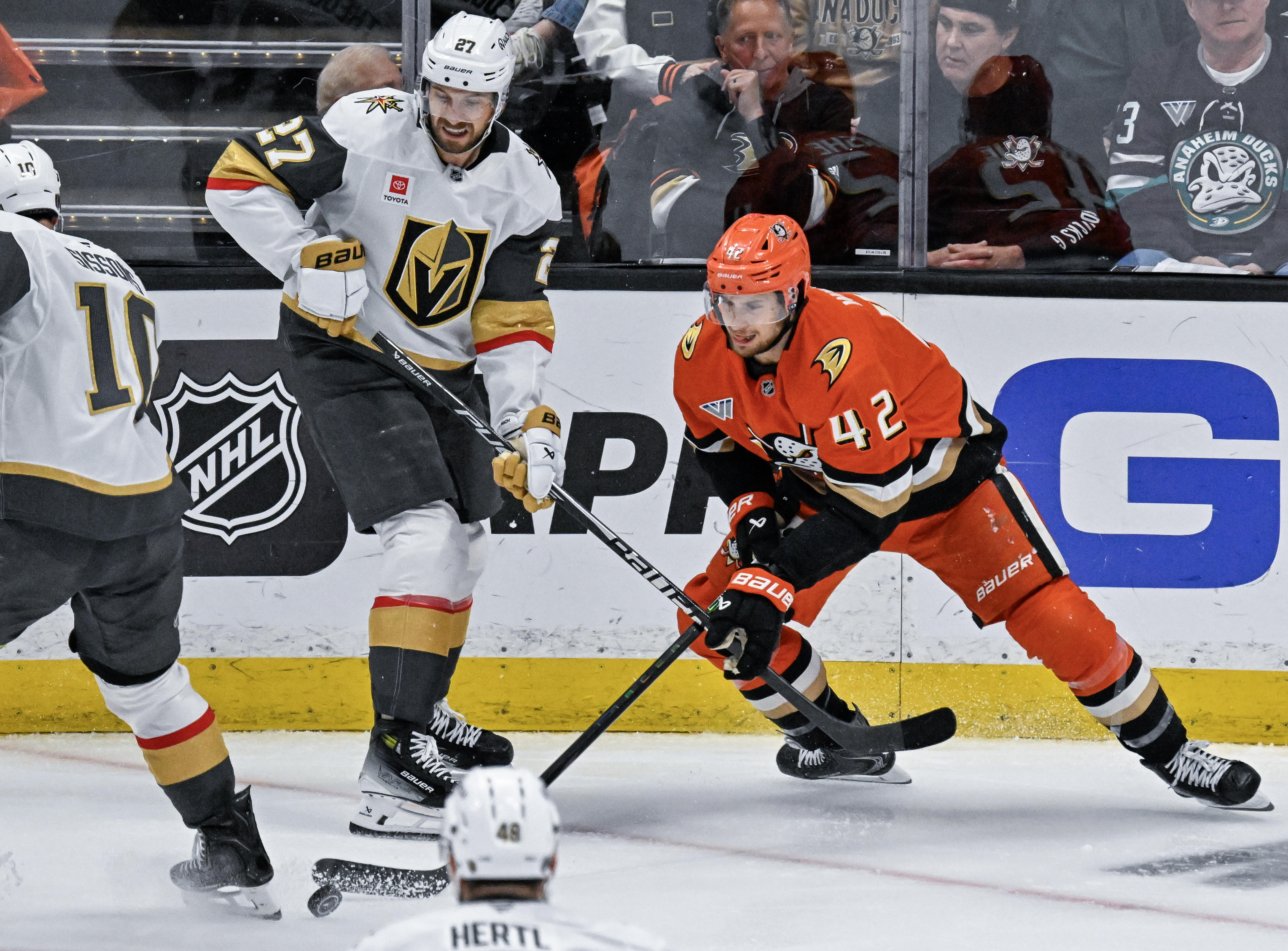 The Ducksâ Tim Washe (42), right, controls the puck, protecting...