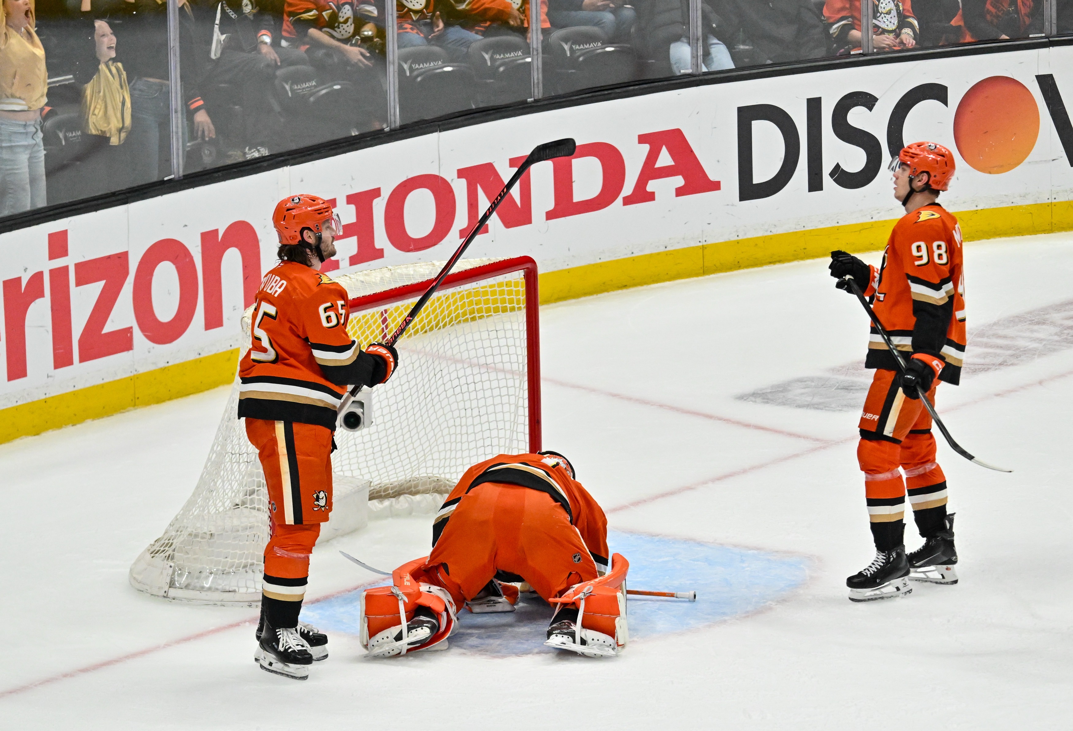 Ducks goaltender Lukas Dostal, center, stays on the ice after...